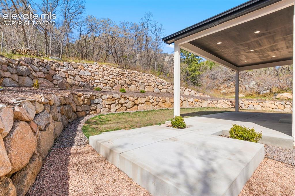 Image 42 of 47: Covered patio with recessed lighting, concrete flooring, and solid support 