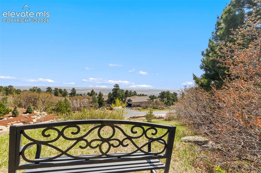 Image 45 of 47: Expansive outdoor space featuring a decorative metal bench, natural landsca