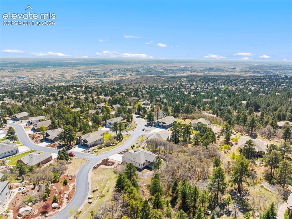 Image 5 of 47: Aerial perspective of a residential neighborhood with a vast distant citysc