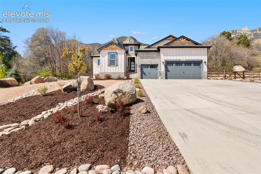 Image 9 of 47: Exterior features stone and vertical siding accents, a two-car garage with 