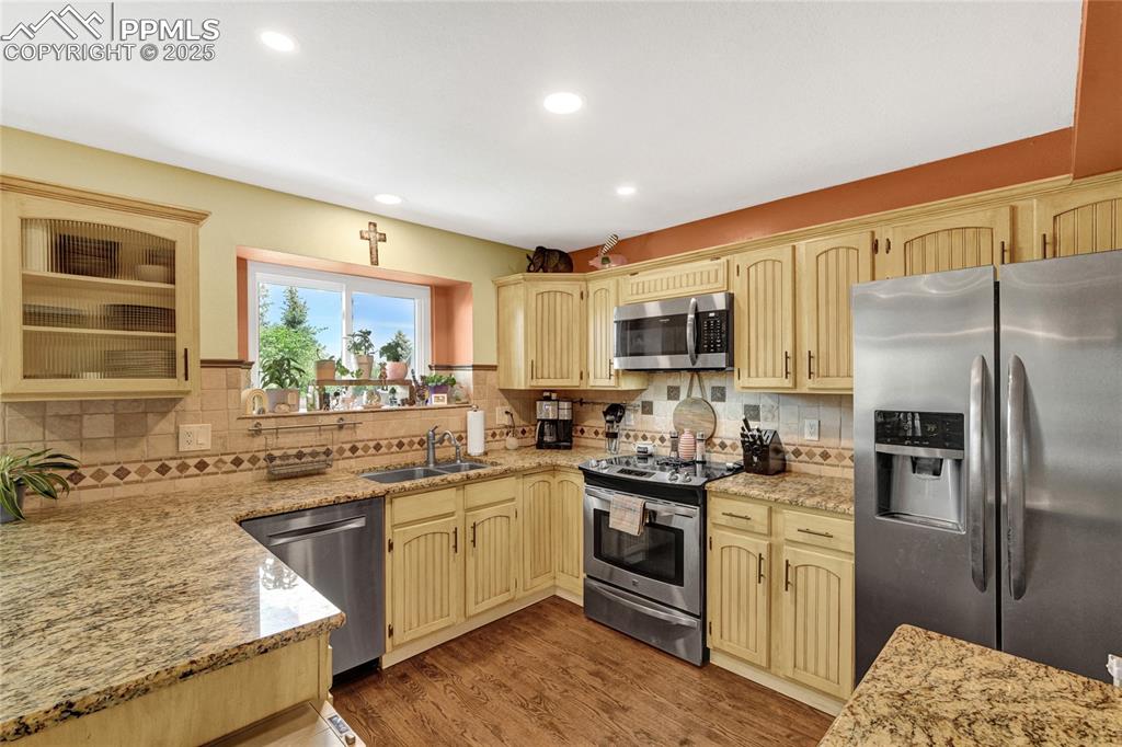 Image 11 of 32: Kitchen with appliances with stainless steel finishes, recessed lighting, b