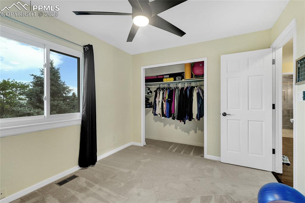 Image 17 of 32: Unfurnished bedroom with light colored carpet, a closet, and a ceiling fan