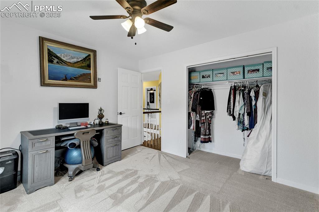 Image 19 of 32: Office space featuring light carpet and a ceiling fan