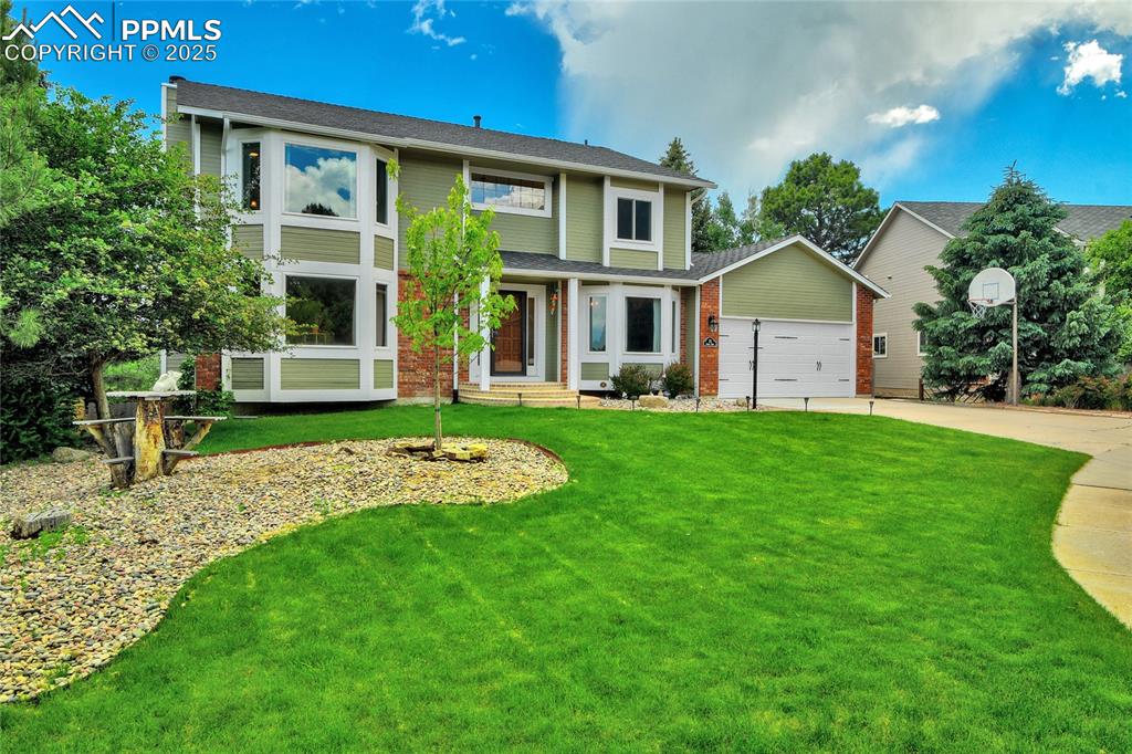 Image 2 of 32: View of front of home with driveway, a front yard, a garage, and roof with