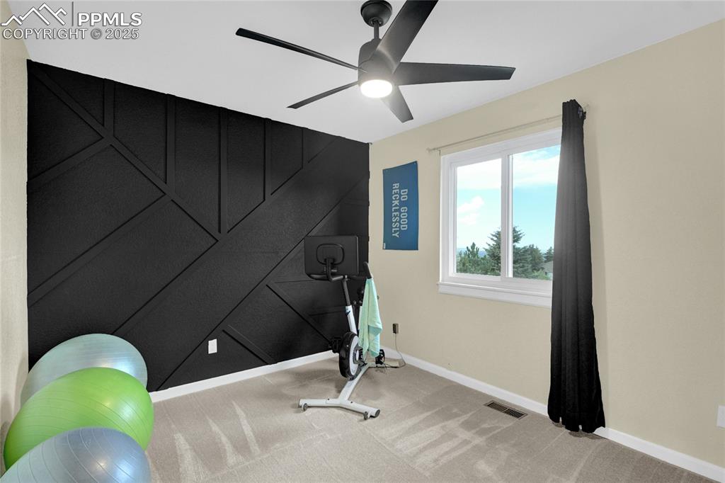 Image 25 of 32: Exercise area with carpet floors and a ceiling fan