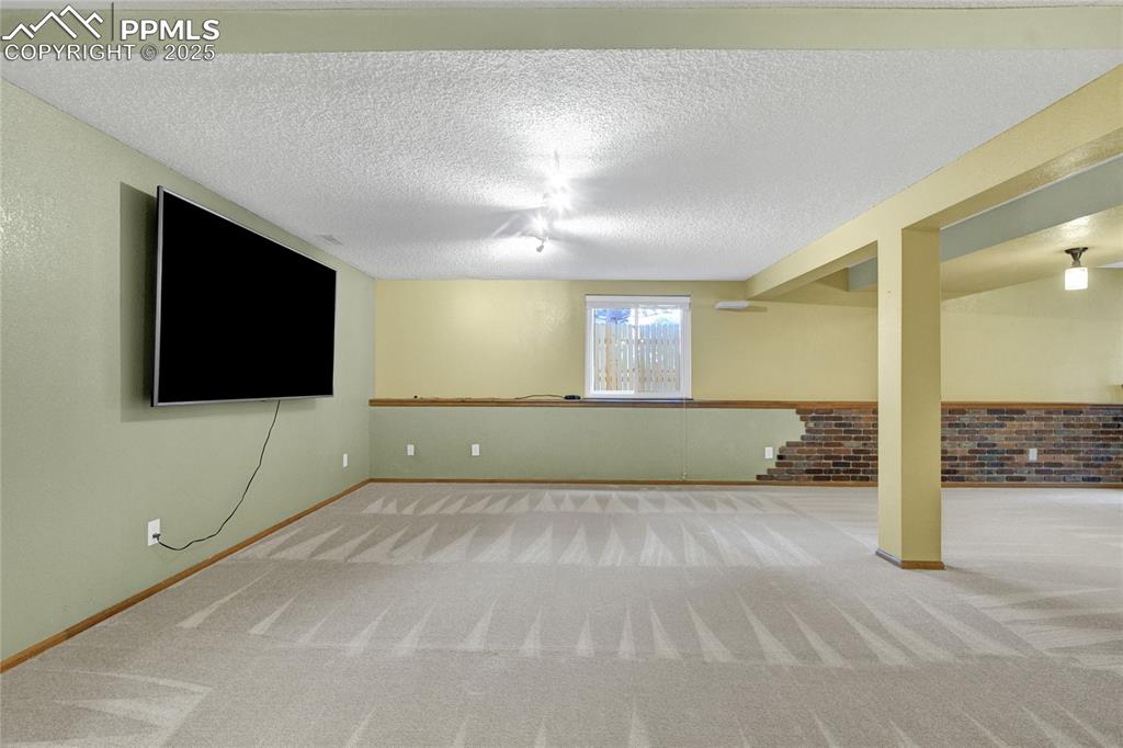 Image 26 of 32: Basement featuring carpet and a textured ceiling