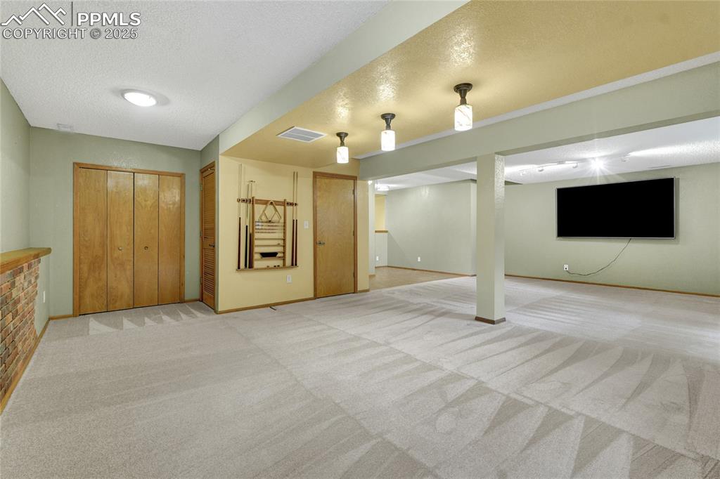 Image 27 of 32: Finished basement featuring a textured ceiling and light colored carpet