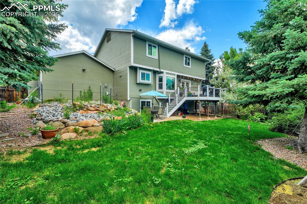 Image 29 of 32: Back of property with a wooden deck, stairs, and a patio