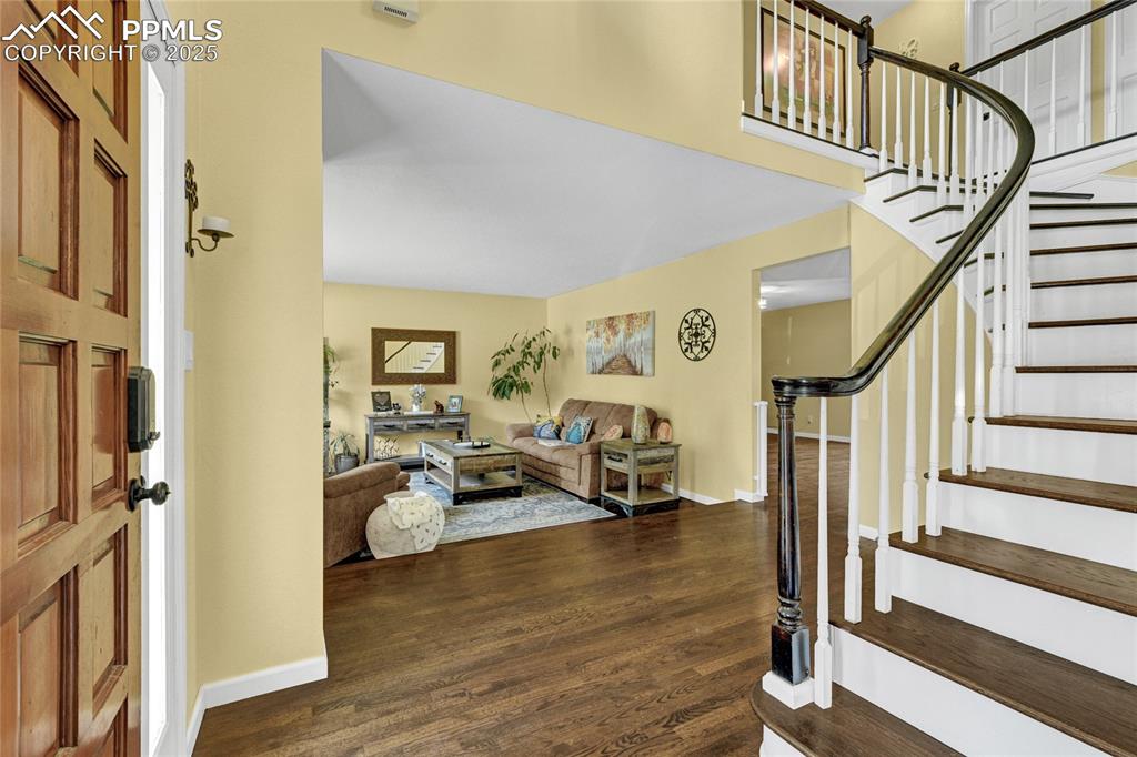 Image 3 of 32: Foyer entrance with dark wood-style flooring and stairway