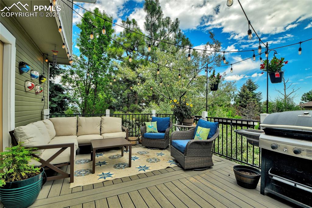 Image 32 of 32: Deck with outdoor lounge area and grilling area