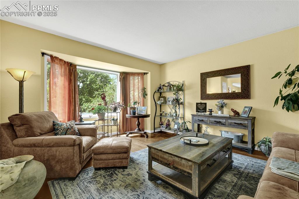 Image 5 of 32: Living area featuring wood finished floors and baseboards