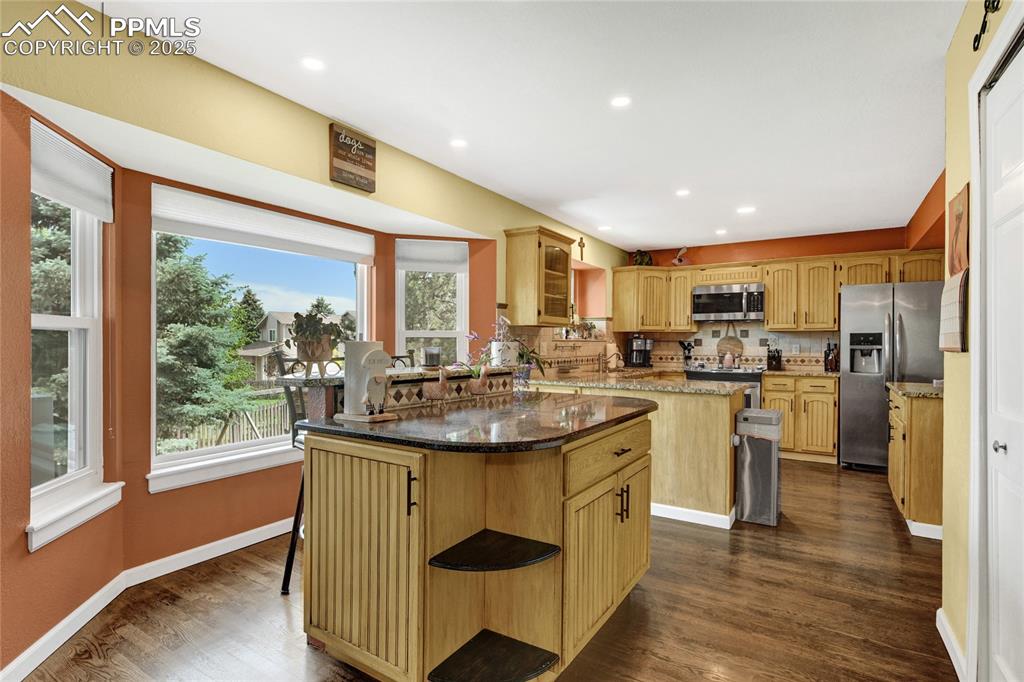 Image 9 of 32: Kitchen with stainless steel appliances, a center island, plenty of natural