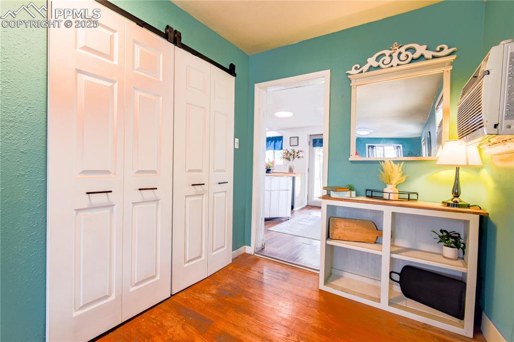 Image 12 of 30: Hallway with wood finished floors and a barn door