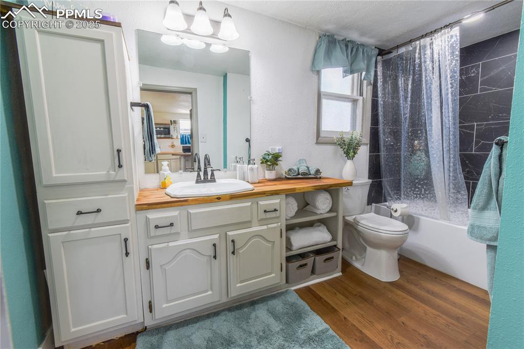 Image 16 of 30: Full bathroom with vanity, shower / tub combo, wood finished floors, toilet