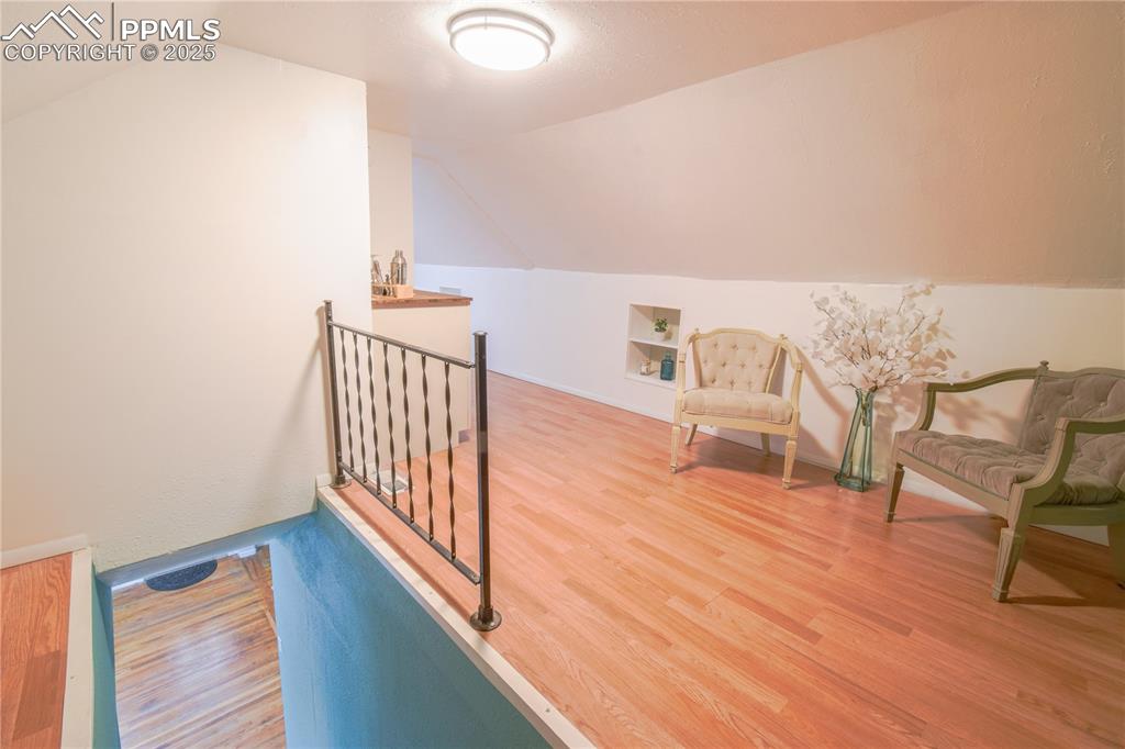 Image 17 of 30: Additional living space featuring vaulted ceiling, wood finished floors, an