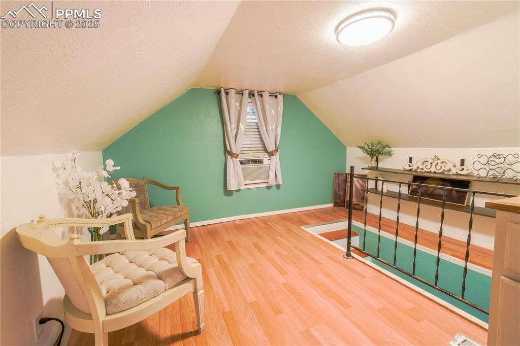 Image 18 of 30: Additional living space featuring wood finished floors, lofted ceiling, bas