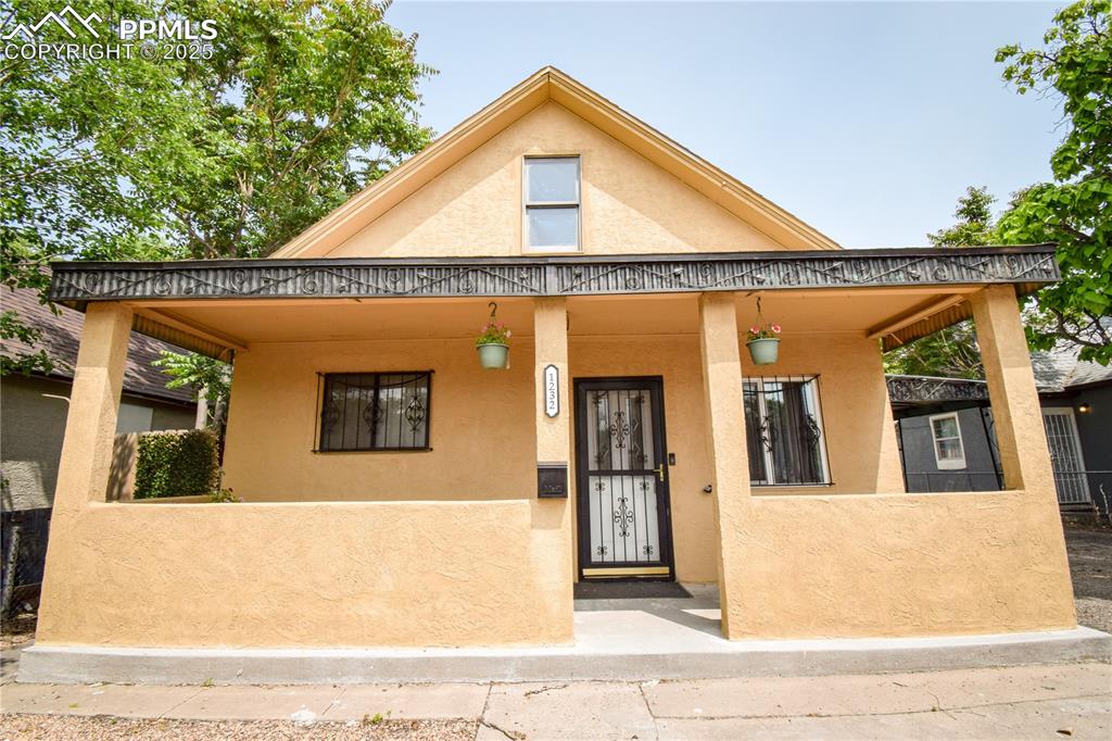 Image 2 of 30: View of front of house featuring stucco siding and covered porch