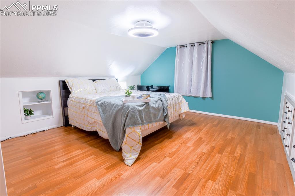 Image 20 of 30: Bedroom featuring light wood-type flooring, vaulted ceiling, and baseboards