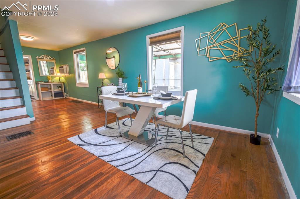 Image 6 of 30: Dining room with hardwood / wood-style floors, stairs, baseboards, and a wa