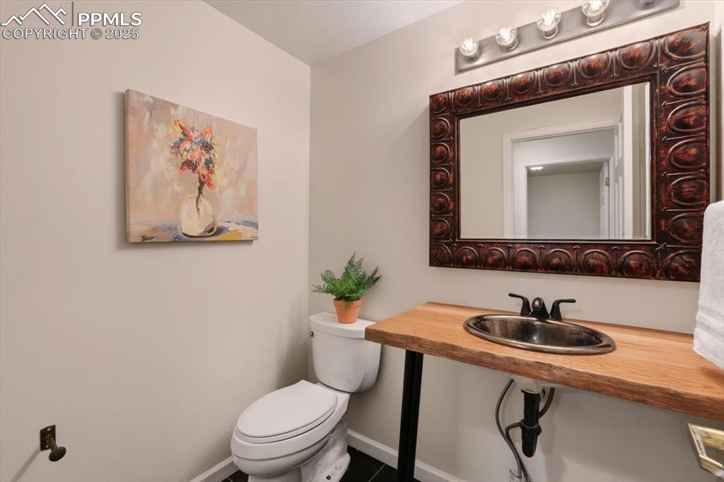 Image 14 of 31: Half bath with toilet and tile patterned floors