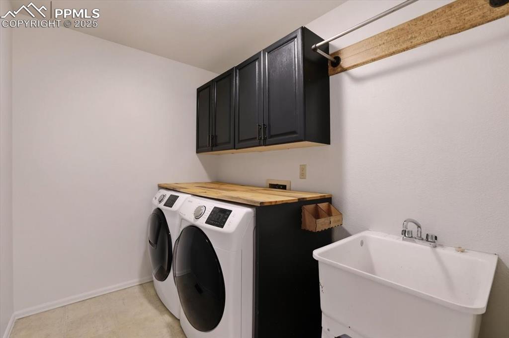 Image 15 of 31: Laundry area with cabinet space and independent washer and dryer