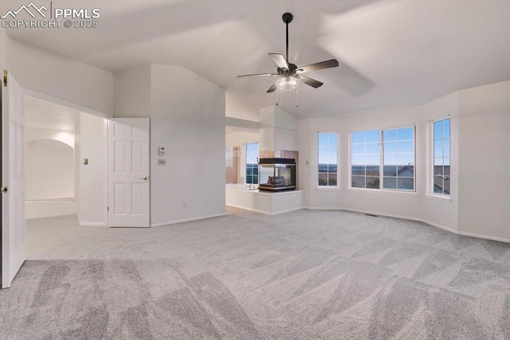 Image 17 of 31: Unfurnished living room featuring lofted ceiling, light carpet, and ceiling