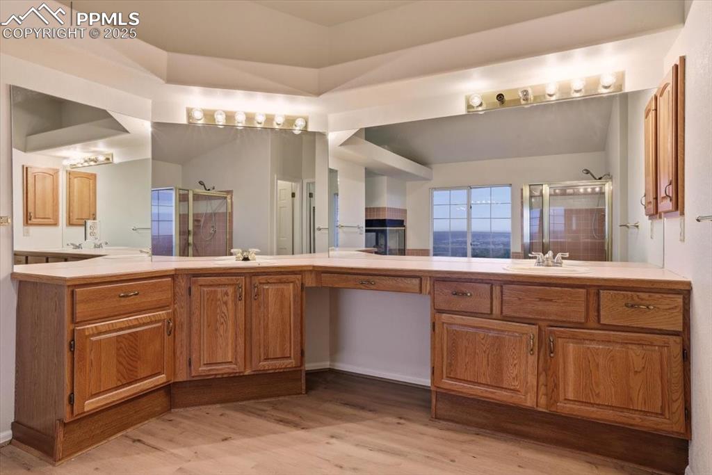 Image 18 of 31: Bathroom with light wood-style floors, two vanities, and a stall shower