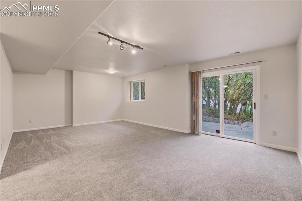 Image 25 of 31: Spare room featuring track lighting and light colored carpet