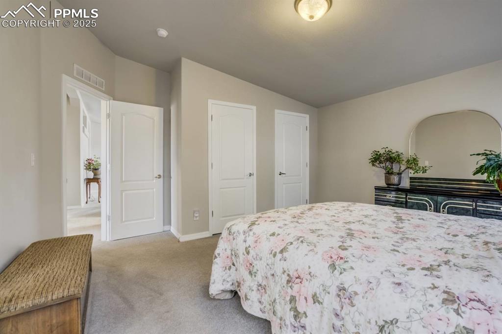 Image 12 of 35: Carpeted bedroom featuring vaulted ceiling and baseboards