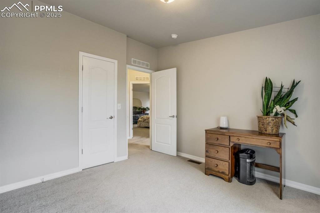 Image 17 of 35: Bedroom featuring light colored carpet and baseboards