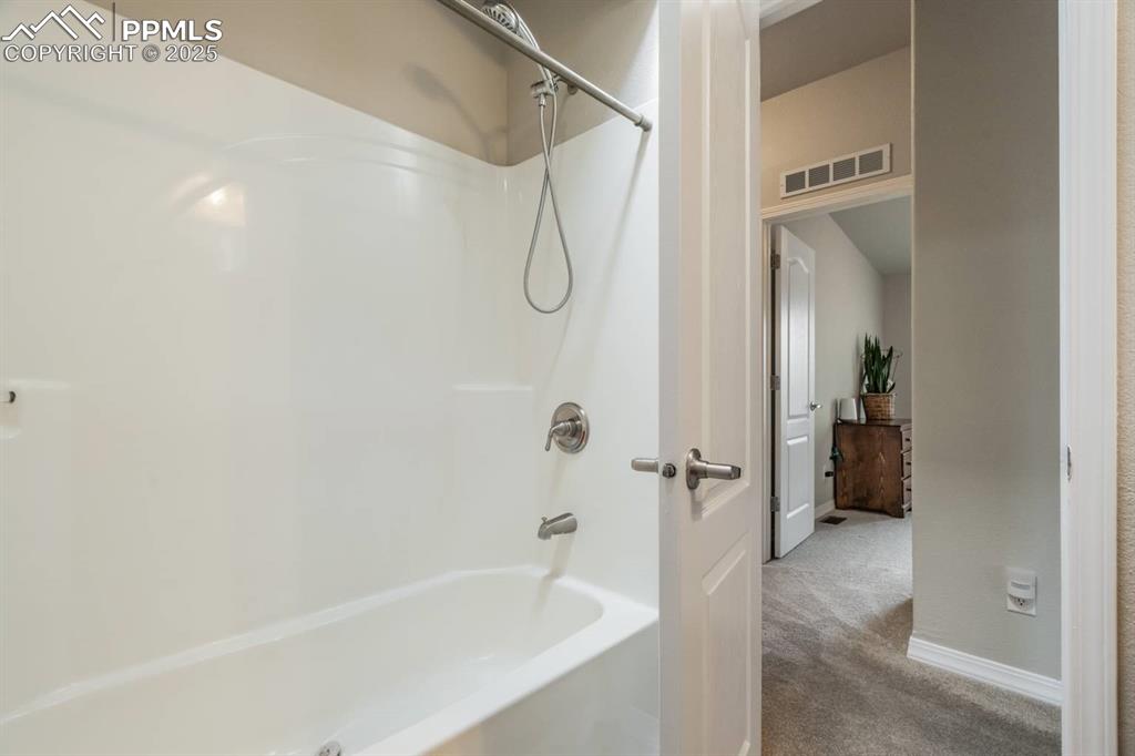 Image 21 of 35: Bathroom featuring shower / bath combination and baseboards