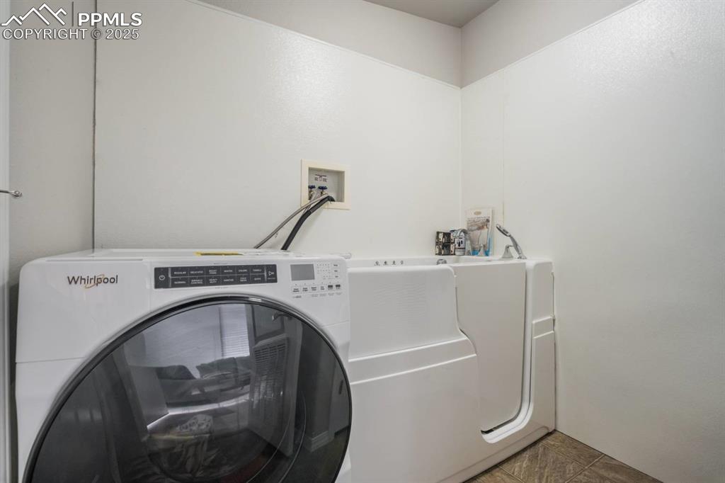 Image 22 of 35: Laundry area with washer / dryer and tile patterned floors