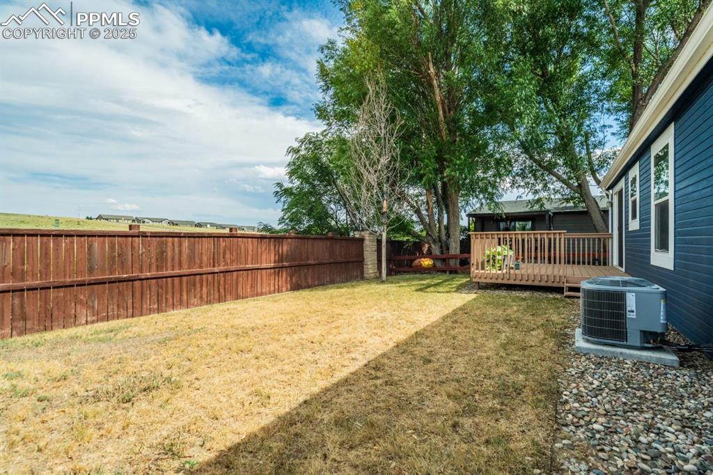 Image 25 of 35: Fenced backyard featuring a wooden deck