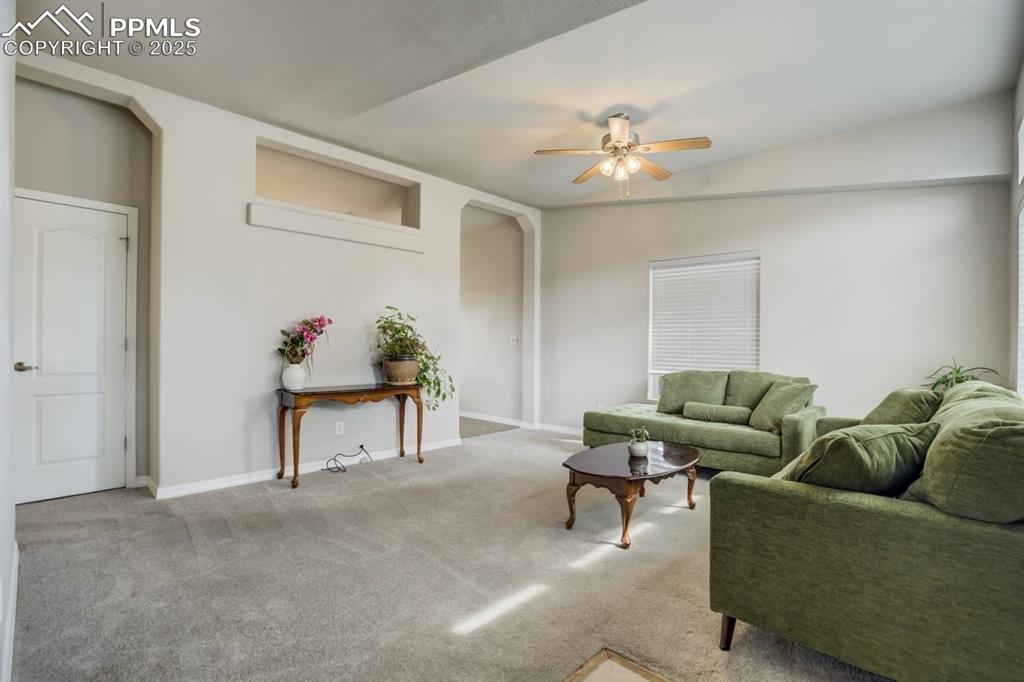 Image 3 of 35: Living room featuring light carpet, ceiling fan, and arched walkways