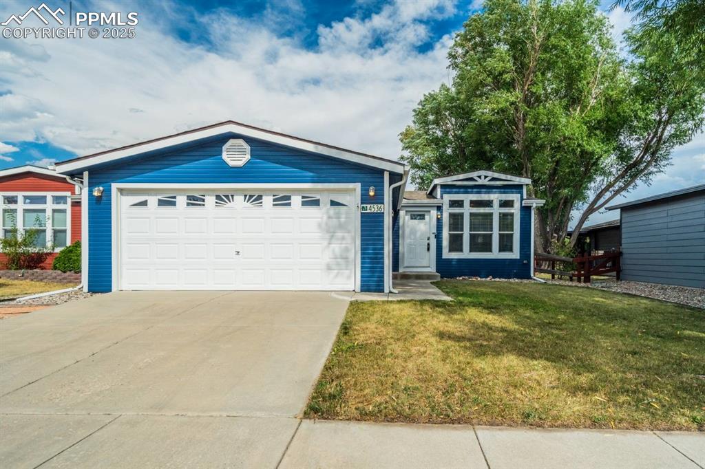 Image 30 of 35: Ranch-style home featuring a front yard, an attached garage, and driveway