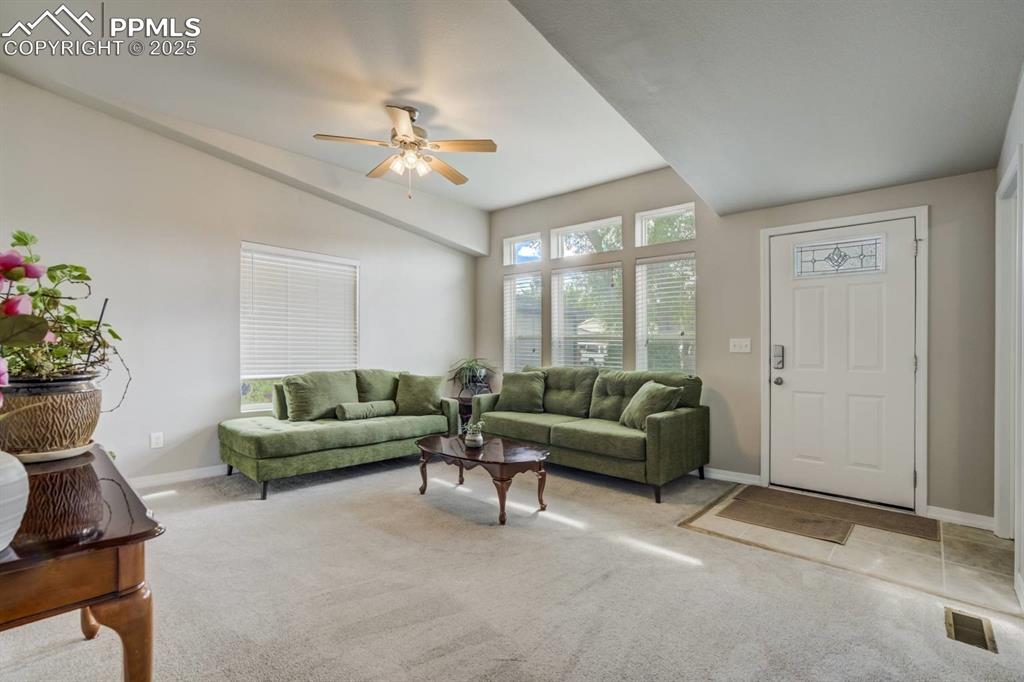 Image 4 of 35: Living room featuring light colored carpet and a ceiling fan