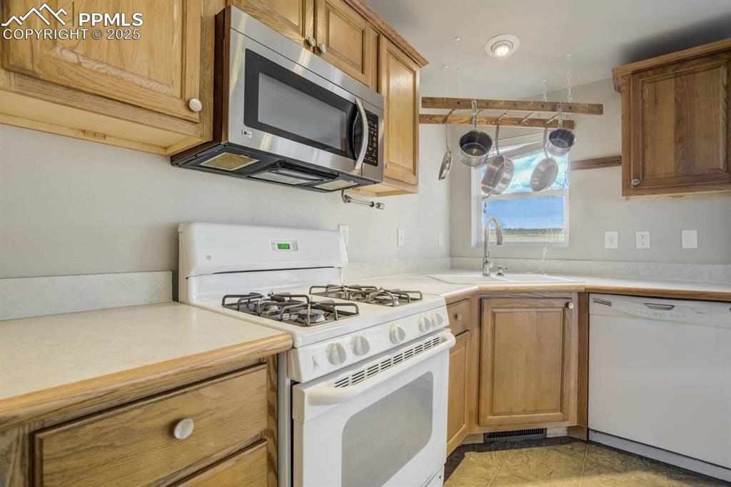 Image 7 of 35: Kitchen with white appliances, light countertops, light tile patterned floo