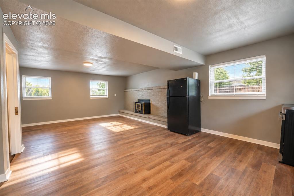 Image 18 of 29: Wood-finish flooring, multiple windows with blinds, recessed lighting, and