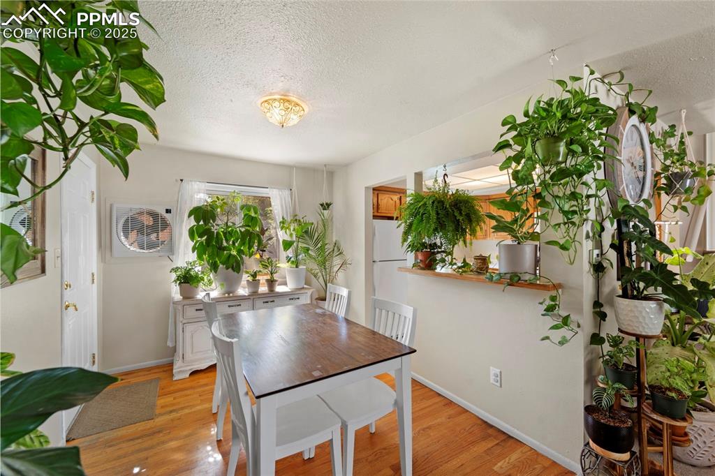 Image 17 of 38: Dining room with a textured ceiling and light wood-style flooring