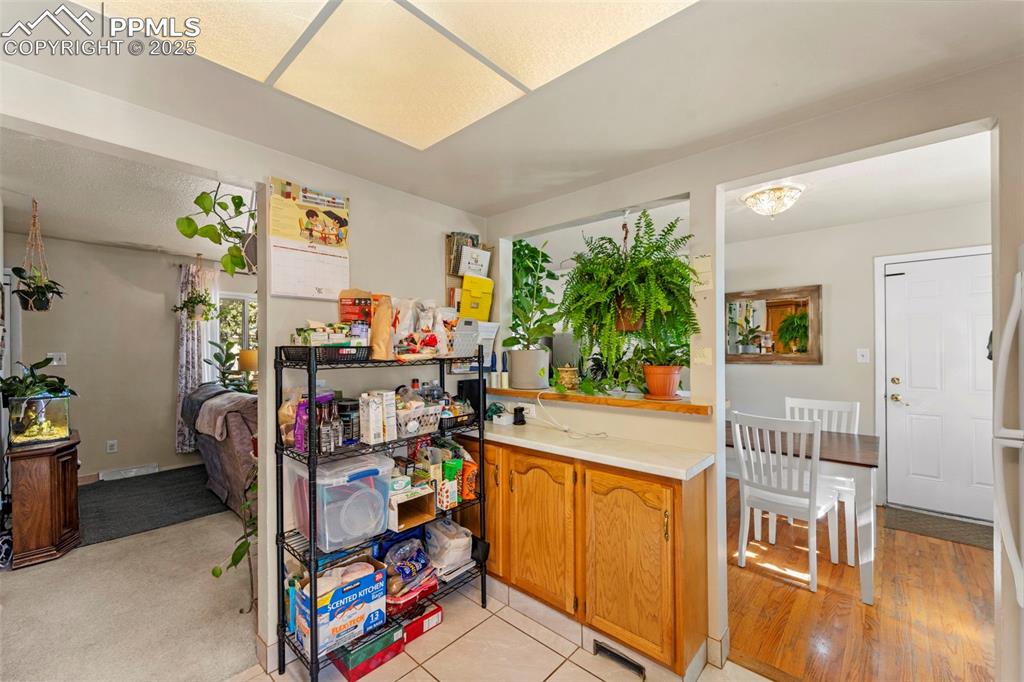 Image 20 of 38: Kitchen featuring light countertops, light carpet, light tile patterned flo