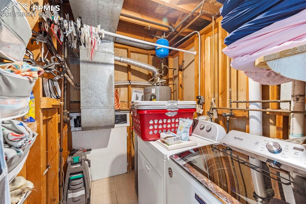 Image 30 of 38: Laundry area featuring washing machine and dryer and tile patterned floorin