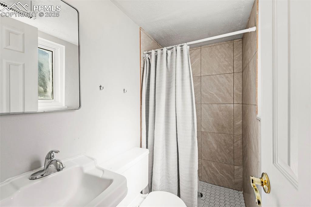 Image 33 of 38: Full bathroom featuring toilet and a shower stall
