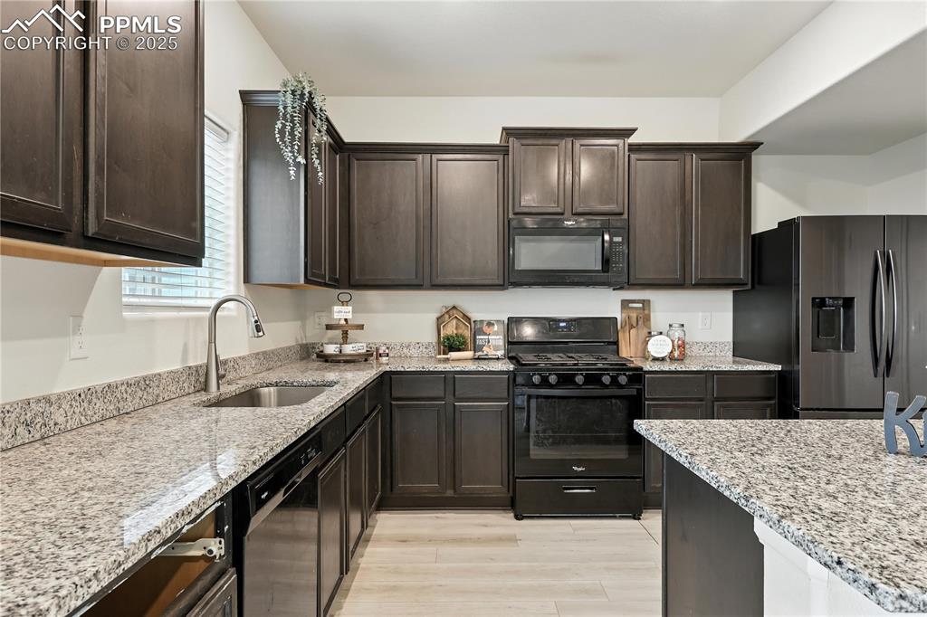 Image 15 of 47: Well appointed kitchen that boasts rich espresso cabinetry, granite counter