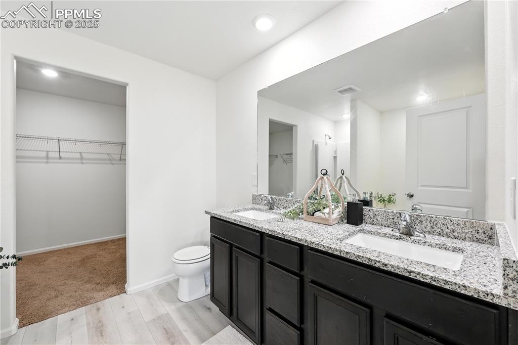 Image 27 of 47: 5-piece Primary Bathroom with dual sink vanity and walk in closet.