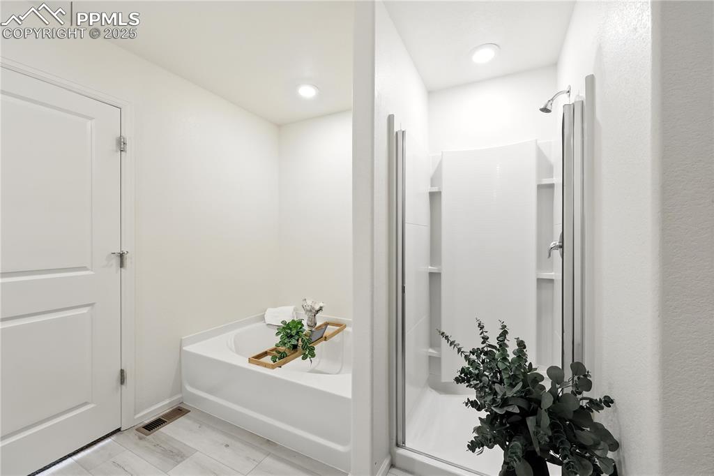 Image 29 of 47: Soaking tub and separate shower in the Primary Bathroom.