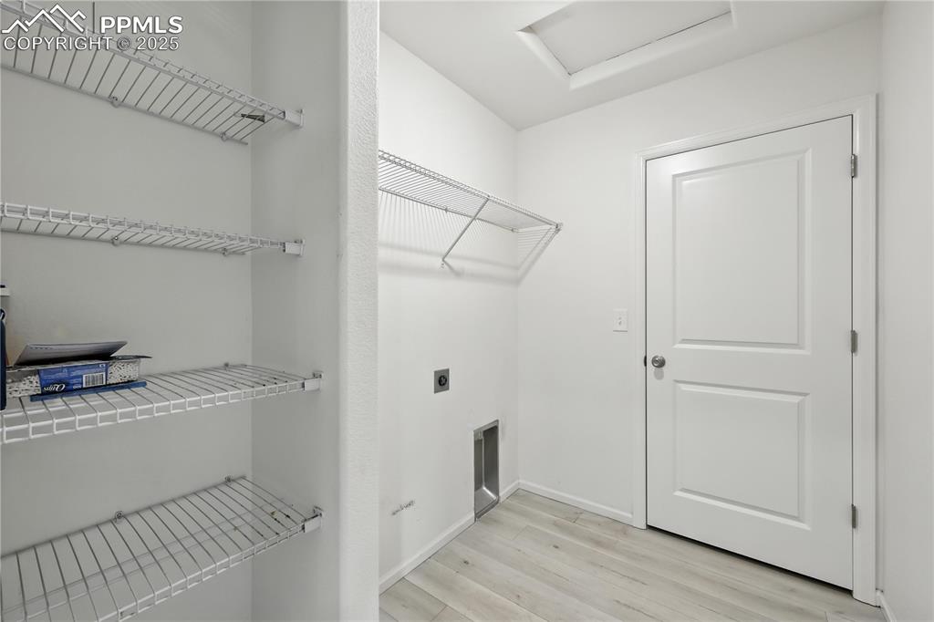 Image 31 of 47: Laundry Room with built-in racks and electric hookup.