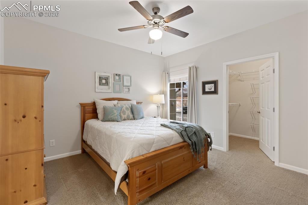 Image 14 of 26: Bedroom with a spacious closet, light carpet, and ceiling fan