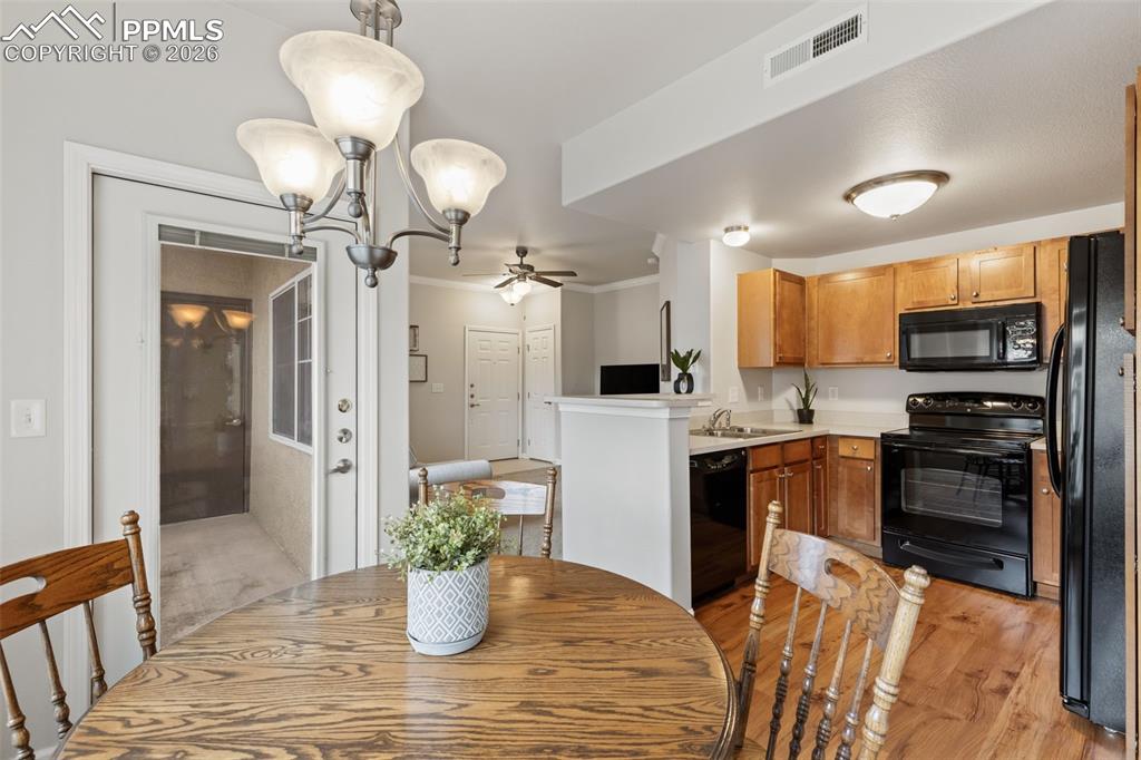 Image 8 of 26: Dining room with a ceiling fan, crown molding, and light wood-style floorin