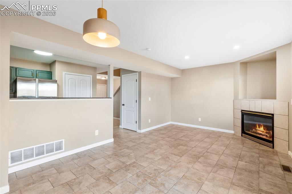 Image 5 of 26: Updated living room with tile floor, gas fireplace; adjacent to dining area