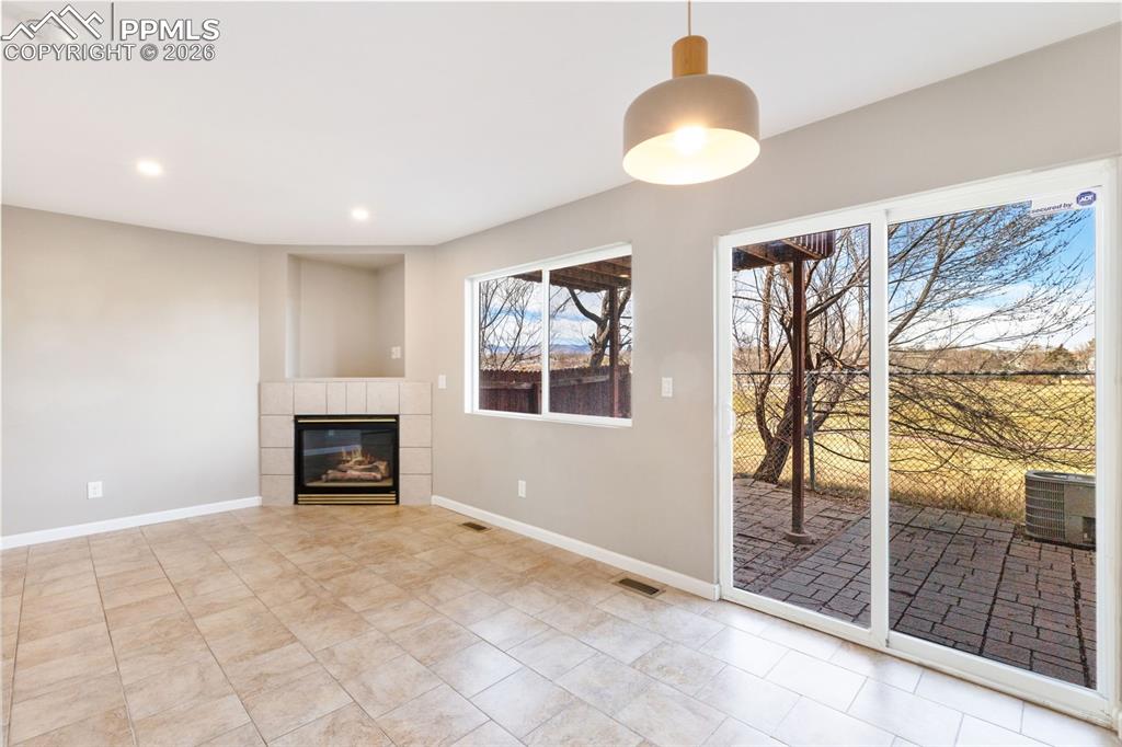 Image 6 of 26: Living room and adjacent dining area has walk-out to patio that backs to th